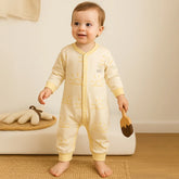 Baby romper in a light cream or beige shade with yellow sun prints